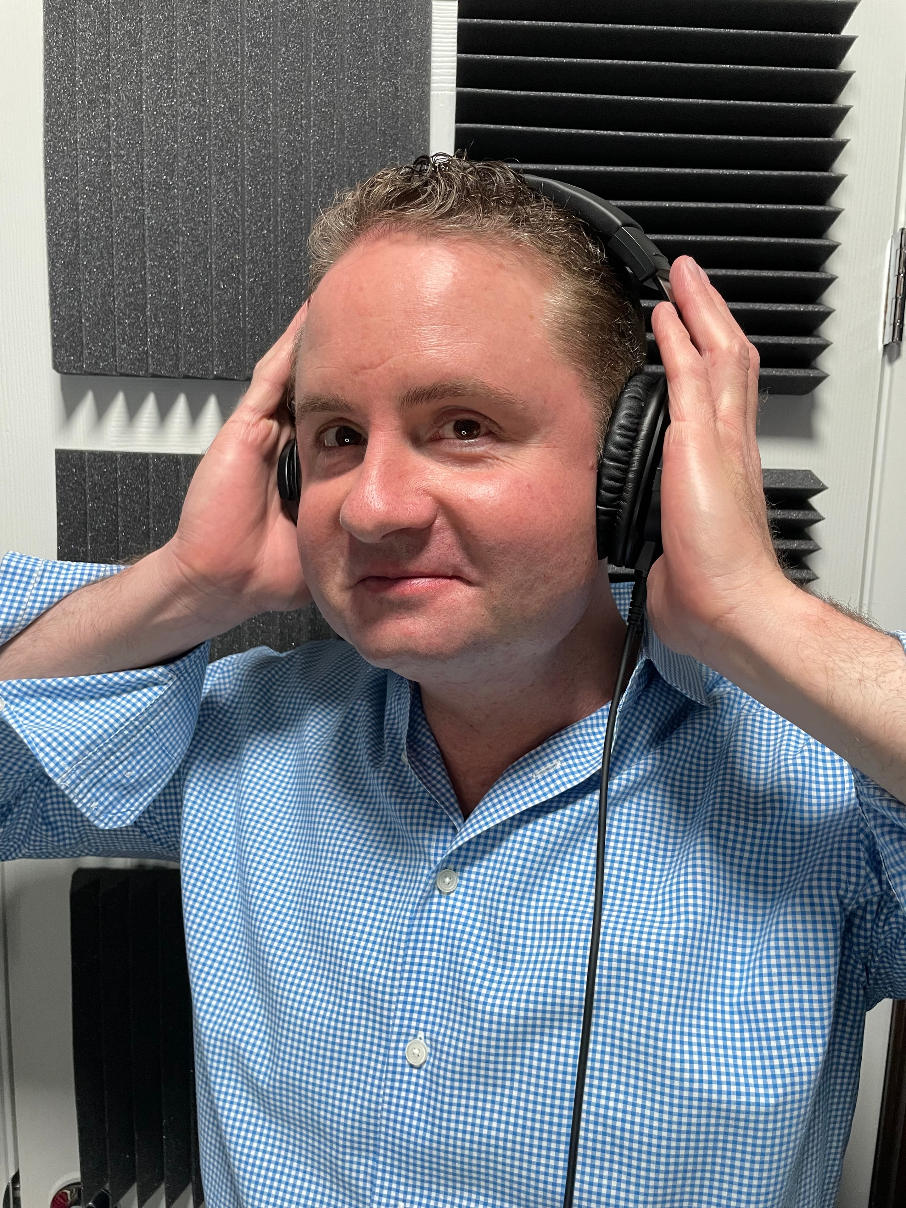 Brandon James in the recording booth with headphones