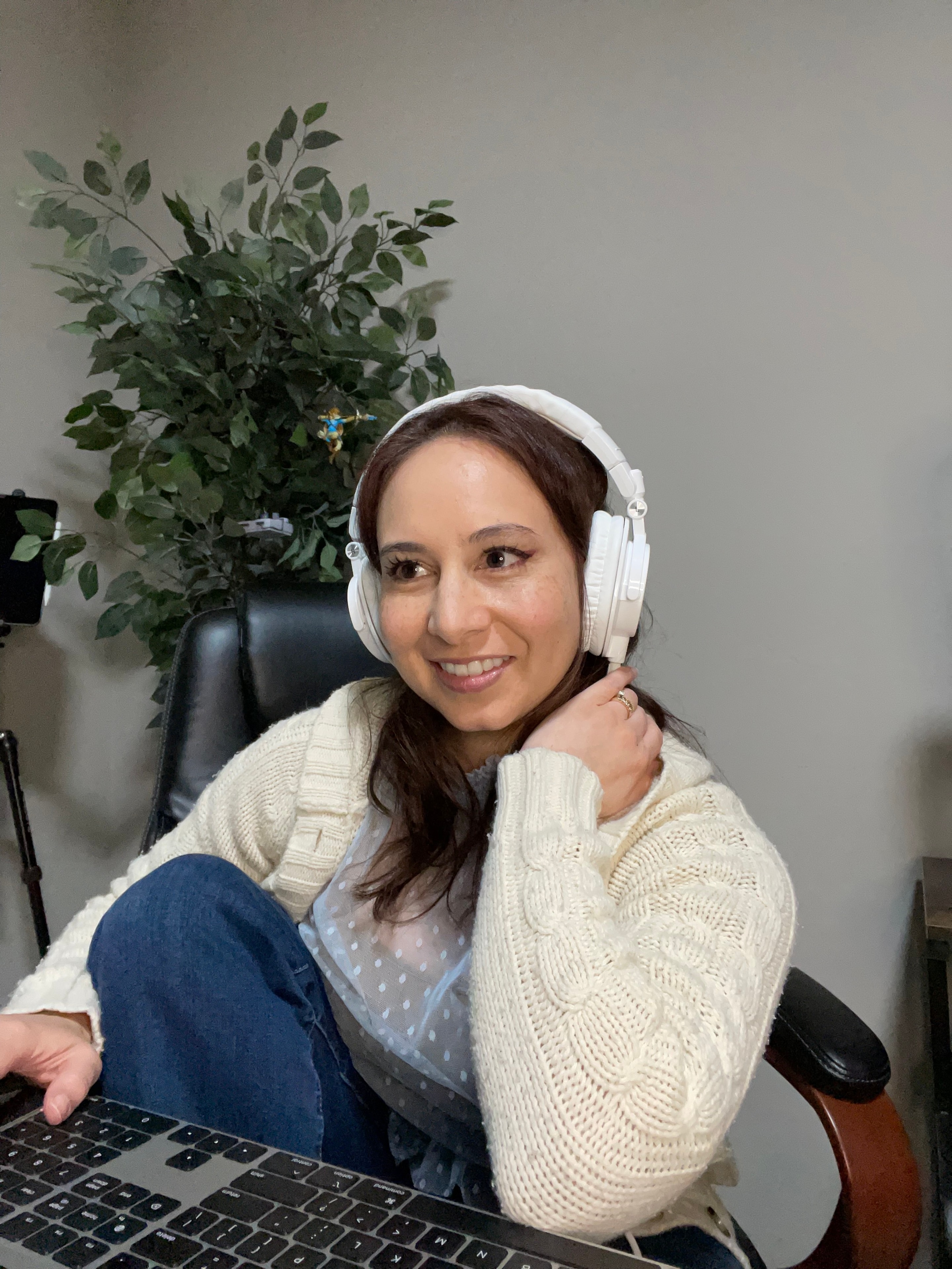 Tina James at her desk with headphones, smiling